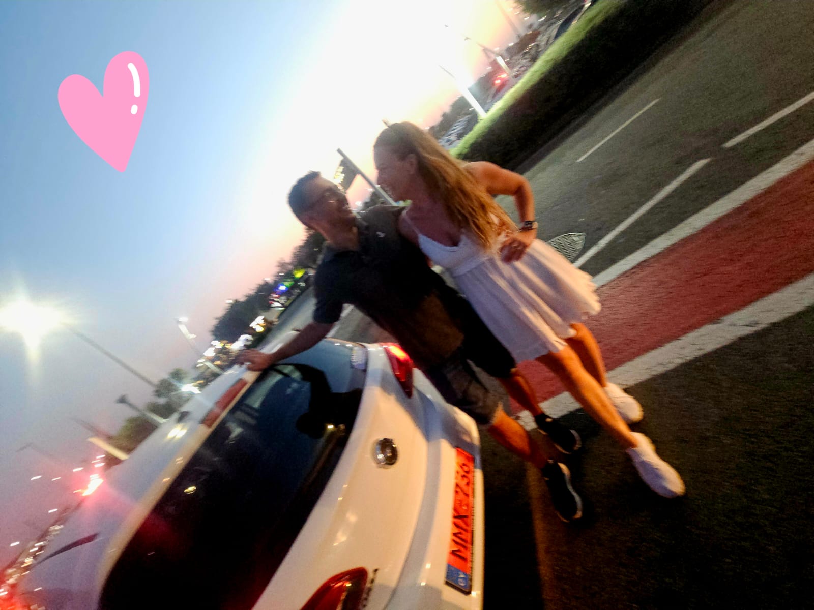 Couple with rental car at sunset